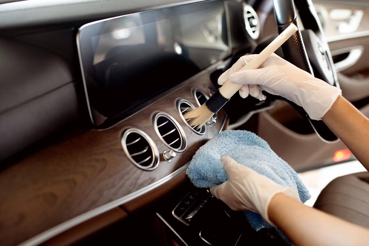 Detailer cleaning and brushing dashboard panel